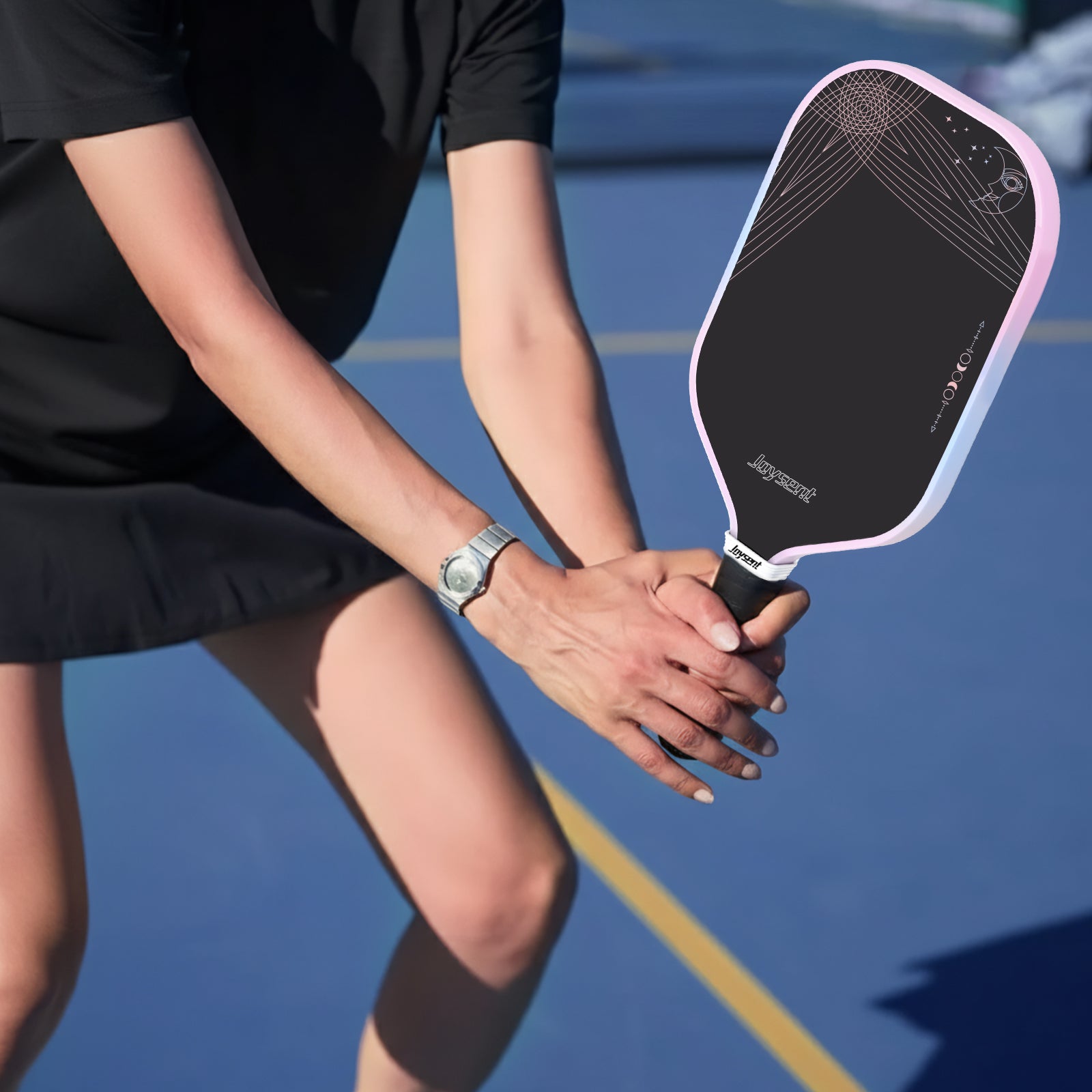 Person holding a pickleball paddle on a court
